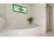 Bathroom with bathtub, tile surround, stained glass window, and walk-in shower at 3690 Lithia Way, Lithia Springs, GA 30122