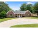Charming brick home with well-manicured lawn and circular driveway, surrounded by mature trees at 3690 Lithia Way, Lithia Springs, GA 30122