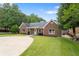Attractive brick home with a circular driveway, lush lawn and manicured landscaping at 3690 Lithia Way, Lithia Springs, GA 30122