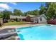 Sparkling in-ground pool with diving board and rear home view surrounded by lush greenery at 3690 Lithia Way, Lithia Springs, GA 30122