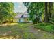 Large, leafy backyard featuring a stone pathway, providing a serene retreat with mature trees at 5271 Oglethorpe Ct, Powder Springs, GA 30127