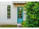 Inviting turquoise door, surrounded by greenery and classic white siding at 5271 Oglethorpe Ct, Powder Springs, GA 30127