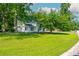 Charming white home on a sprawling lawn, shaded by mature trees, inviting curb appeal at 5271 Oglethorpe Ct, Powder Springs, GA 30127