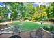 Large backyard with lush green grass, trees, and an outdoor shed for storage at 1784 Virginia Grove Ln, Lawrenceville, GA 30045