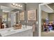 Bathroom featuring double sinks, a large framed mirror and a doorway leading to another bedroom at 1784 Virginia Grove Ln, Lawrenceville, GA 30045