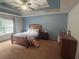 This bedroom features a tray ceiling with ceiling fan, neutral walls, and a large window at 1784 Virginia Grove Ln, Lawrenceville, GA 30045