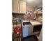 Functional laundry room with modern washer, dryer, storage cabinets, and decorative art at 1784 Virginia Grove Ln, Lawrenceville, GA 30045