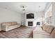 Bright living room featuring hardwood floors, a fireplace, neutral decor, and a ceiling fan at 1786 Jameson Cir, Lawrenceville, GA 30043