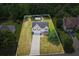 Aerial view of a well-maintained home with a spacious yard, framed by lush trees and a convenient driveway at 185 Fox Run, Loganville, GA 30052