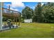 Relaxing backyard featuring a covered deck with outdoor seating, a patio with a grill, and a storage shed at 185 Fox Run, Loganville, GA 30052