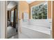 The bathroom features a large soaking tub beneath a window for abundant light at 185 Fox Run, Loganville, GA 30052