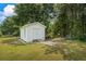 White storage shed located in the backyard with double doors and a ramp for easy access at 185 Fox Run, Loganville, GA 30052