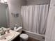 Bathroom with a shower-tub combo, striped wallpaper, and a new toilet at 1106 Shiloh Nw Ln, Kennesaw, GA 30144