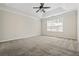 Spacious bedroom with neutral walls, carpet, and a ceiling fan with a tray ceiling and a bright window at 122 Creighton Ln, Marietta, GA 30008
