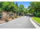 Community entrance with stone signage, a gated entry, and mature trees at 122 Creighton Ln, Marietta, GA 30008