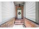 Charming front entrance featuring brick steps, a covered porch, and a decorative wreath at 122 Creighton Ln, Marietta, GA 30008