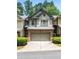 Attractive townhouse featuring brick accents, a two-car garage, and tidy landscaping at 122 Creighton Ln, Marietta, GA 30008