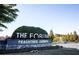 A welcoming sign for The Forum at Peachtree Corners, set against a backdrop of green shrubbery and manicured trees at 3272 Monarch Pine Dr, Peachtree Corners, GA 30071