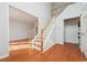 Light-filled foyer featuring hardwood floors, a staircase, and an open doorway to the living area at 3272 Monarch Pine Dr, Peachtree Corners, GA 30071