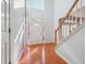 Bright foyer featuring hardwood floors, staircase with wood railing, and a decorative front door at 3272 Monarch Pine Dr, Peachtree Corners, GA 30071