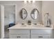 Bright bathroom featuring double sinks with white countertops at 738 Woodstock Grove Dr, Woodstock, GA 30188