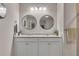 Bright bathroom featuring double sinks, granite countertops and round mirrors at 738 Woodstock Grove Dr, Woodstock, GA 30188