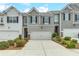 Charming townhome featuring a two-car garage, gray siding, and lovely landscaping at 738 Woodstock Grove Dr, Woodstock, GA 30188