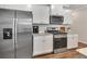 The bright kitchen features stainless appliances, white cabinets, granite countertops, and a subway tile backsplash at 738 Woodstock Grove Dr, Woodstock, GA 30188
