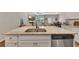 Spacious kitchen island with stainless steel sink and dishwasher offering an open view to the living and dining areas at 738 Woodstock Grove Dr, Woodstock, GA 30188