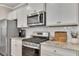 Updated kitchen featuring stainless steel appliances, granite countertops, white cabinets, and a subway tile backsplash at 738 Woodstock Grove Dr, Woodstock, GA 30188