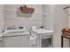 Modern laundry room with a front load washer, dryer and storage shelves at 738 Woodstock Grove Dr, Woodstock, GA 30188