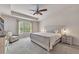 Relaxing main bedroom with tray ceilings, ceiling fan, neutral paint, and a large window at 738 Woodstock Grove Dr, Woodstock, GA 30188