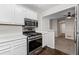 Well-lit kitchen featuring stainless steel appliances, white cabinets, and a view to the adjacent room at 1910 Countryside Se Pl, Smyrna, GA 30080