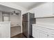 Kitchen featuring stainless steel refrigerator and white cabinets adjacent to dining area at 1910 Countryside Se Pl, Smyrna, GA 30080
