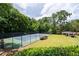Outdoor tennis court surrounded by lush trees and a gazebo in a beautiful community at 1910 Countryside Se Pl, Smyrna, GA 30080