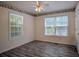 Bedroom featuring stylish wood-look flooring, ceiling fan, and natural light at 217 Bridgewater Trl, Canton, GA 30115