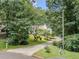 A home is nestled among mature trees, with a long driveway and landscaped front yard at 217 Bridgewater Trl, Canton, GA 30115