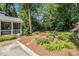 Landscaped backyard with mulched garden beds and walkway leading to screened-in porch at 6300 Blackwater Trl, Atlanta, GA 30328