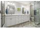 Modern bathroom equipped with a double vanity, marble countertops, updated fixtures, and a glass shower at 6300 Blackwater Trl, Atlanta, GA 30328
