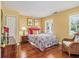 Cozy bedroom with wood floors, featuring a charming bed, a wicker chair, and ample natural light at 6300 Blackwater Trl, Atlanta, GA 30328