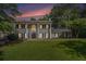 Elegant two-story home with classic columns, manicured lawn, and lush landscaping at 6300 Blackwater Trl, Atlanta, GA 30328