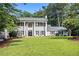 Two-story home featuring a manicured lawn, complemented by stately columns and black shutters at 6300 Blackwater Trl, Atlanta, GA 30328