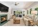 Bright living room featuring a fireplace, large windows, and access to an outdoor living space at 6300 Blackwater Trl, Atlanta, GA 30328