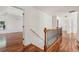 Upstairs hallway with decorative railing, hardwood flooring, and a view into bedrooms at 2761 Valley Spring Dr, Lawrenceville, GA 30044