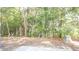 A serene view of a backyard filled with lush green trees and a warning sign at 3165 Creston Park Ct, Duluth, GA 30096