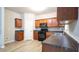 Modern kitchen with sleek dark countertops, wooden cabinets, black appliances, and wood-look flooring at 3165 Creston Park Ct, Duluth, GA 30096