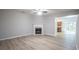 Spacious living room featuring a cozy fireplace, wood-look floors, and access to kitchen and outdoor area at 3165 Creston Park Ct, Duluth, GA 30096