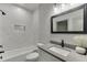 This bathroom features marble tile surround, black fixtures, framed mirror, and great lighting at 4208 Sierra Creek Ct, Hoschton, GA 30548