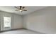 This bedroom offers natural light from the window and features neutral paint, carpet, and a ceiling fan at 4208 Sierra Creek Ct, Hoschton, GA 30548