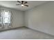 Cozy bedroom features a ceiling fan, neutral paint, carpeted floors, and a window with curtains at 4208 Sierra Creek Ct, Hoschton, GA 30548